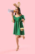 © Pixel-Shot - Beautiful woman in bunny ears with Easter eggs shouting into megaphone on pink background