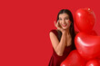 © Pixel-Shot - Happy young woman with kiss marks on her face and heart shaped air balloons on red background