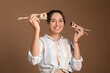 © Pixel-Shot - Happy young woman with different sushi on brown background