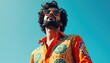 © Pete - Man with curly hair wears bright patterned shirt and sunglasses. He looks up against clear blue sky. This is a vibrant retro fashion portrait.