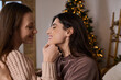 © LIGHTFIELD STUDIOS - Cozy moments shared by a loving lesbian couple during the winter holiday season