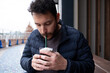 © Ladanifer - Young man enjoying a delicious cold beverage with whipped cream and a straw outdoors