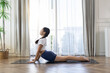 © Ratirat - Asian woman practicing cobra yoga pose on mat at home. Healthy lifestyle, flexibility and wellness concept in bright living room with natural light and peaceful atmosphere.