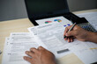 © DK_STUDIO - Business professional preparing tax return documents with calculator and laptop. Concept of income tax filing, financial planning, accounting services and regulatory compliance in office.