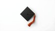 © Farhan - A black graduation cap with an orange tassel on a white background
