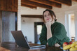 © olezzo - Mature caucasian woman dreaming and smiling while working on laptop at home office