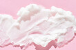 © elenavolf - Smooth white cream texture on soft pink background for skincare and beauty concepts.