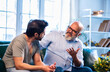 © StockImageFactory - Indian retired dad and grown son in deep conversation on living room sofa