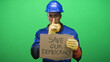 © Krakenimages.com - Man construction worker in blue hardhat holds cardboard sign reading save our democracy and finger to lips for silence in studio; urgent civic concern.