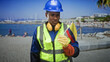 © Krakenimages.com - Man construction worker holds colombian flag with gloved hand, wearing blue hardhat and high visibility vest on street; pride duty.