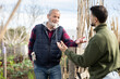 © JackF - Young man have friendly conversation with eldery man while working together in garden