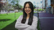© Krakenimages.com - Young chinese woman smiling confidently with arms crossed standing on a vibrant city street outdoors.