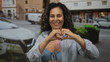© Krakenimages.com - Hispanic woman in a blue bikini and striped shirt stands outdoors on a busy street, smiling joyfully.