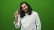 © Krakenimages.com - Young man with long hair and white shirt showing peace sign with hand in green studio; playful optimism.