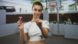 © Krakenimages.com - Woman with short hair holding a pink razor and points finger to camera in building courtyard; confidence self care.