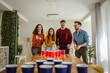 © Miljan Živković - Friends celebrating and playing exciting beer pong game