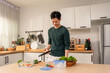 © Kawee - Asian young man cooking healthy foods in kitchen in morning at home.