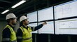 © Purple 1 - Two engineers in hard hats examining a large screen display