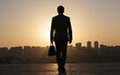 © YiuCheung - Silhouetted businessman walks alone at sunset city skyline fades