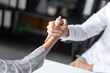 © Charlie's - Businessman Extending Arm for a Handshake with Team Spirit.