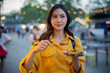 © Laingzaifa - An Asian woman is strolling through a night market, enjoying traditional street food, colorful lanterns, and smiling at the bustling city stalls. It's a vibrant atmosphere and a wonderful cultural
