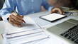 © Lek - close up shot, asian businessman reviewing document using tablet and laptop working. professional lawyer reading and checking business documents and contract