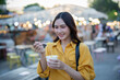 © Laingzaifa - Asian women enjoy delicious street food at night markets, smiling throughout their vacation, exploring the city's culture, vibrant lights, and fun-filled adventures.