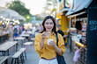 © Laingzaifa - Asian women enjoy delicious street food at night markets, smiling throughout their vacation, exploring the city's culture, vibrant lights, and fun-filled adventures.