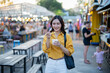 © Laingzaifa - Asian women enjoy delicious street food at night markets, smiling throughout their vacation, exploring the city's culture, vibrant lights, and fun-filled adventures.