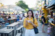 © Laingzaifa - Asian women enjoy delicious street food at night markets, smiling throughout their vacation, exploring the city's culture, vibrant lights, and fun-filled adventures.