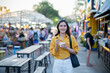 © Laingzaifa - Asian women enjoy delicious street food at night markets, smiling throughout their vacation, exploring the city's culture, vibrant lights, and fun-filled adventures.