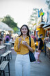 © Laingzaifa - Asian women enjoy delicious street food at night markets, smiling throughout their vacation, exploring the city's culture, vibrant lights, and fun-filled adventures.