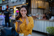 © Laingzaifa - Asian women enjoy delicious street food at night markets, smiling throughout their vacation, exploring the city's culture, vibrant lights, and fun-filled adventures.