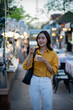 © Laingzaifa - Asian women enjoy delicious street food at night markets, smiling throughout their vacation, exploring the city's culture, vibrant lights, and fun-filled adventures.