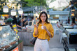 © Laingzaifa - Asian women enjoy delicious street food at night markets, smiling throughout their vacation, exploring the city's culture, vibrant lights, and fun-filled adventures.