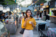 © Laingzaifa - Asian women enjoy delicious street food at night markets, smiling throughout their vacation, exploring the city's culture, vibrant lights, and fun-filled adventures.