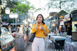 © Laingzaifa - Asian women enjoy delicious street food at night markets, smiling throughout their vacation, exploring the city's culture, vibrant lights, and fun-filled adventures.