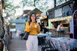 © Laingzaifa - Asian women enjoy delicious street food at night markets, smiling throughout their vacation, exploring the city's culture, vibrant lights, and fun-filled adventures.