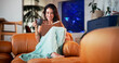 © EineroLens25/peopleimages.com - Coffee, reading book and woman on sofa in home for hobby, relax and literature for learning. Happy, house and person with drink and novel, story or fiction for peace, calm and literacy in living room
