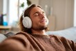 © ttonaorh - Young man relaxing with headphones at home