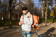 © Oscar - Courier man checking smartphone for food delivery