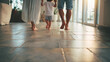 © AnastasiiaAkh - Barefoot family walking warm floor home comfort lifestyle interior heating