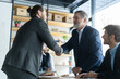 © opolja - Happy business men executive partners making agreement with handshake at team meeting