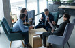© opolja - Business team sitting around a table in a meeting room, having business meeting to discuss plans