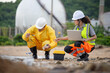© JU.STOCKER - Team of specialized technicians performing water quality testing and ecological monitoring at coastal site with gas storage tanks, Environmental researchers analyzing water samples and recording data