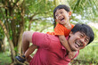 © tuan12 - Asian man giving piggy back to his little boy, enjoy and laughing together, joyful parenting and quality time concept