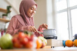 © Art_Photo - Happy young asian muslim woman in hijab cooking healthy food in kitchen at home, Islamic housewife preparing halal meal with vegetables, ramadan Iftar, homemade dinner and domestic lifestyle concept