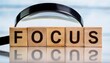 © Kelly - the word focus is made of wooden letters with a magnifying glass selective focus