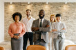 © Westend61 - Confident business team smiling in office group portrait
