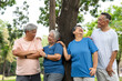 © Prot - Four older adults enjoy a cheerful moment together in a lush outdoor setting. Their smiles and relaxed poses highlight themes of friendship, active aging, and joy of social connection in later life.